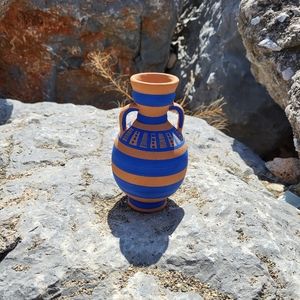 Terracotta vase with vibrant blue hand painted motif.